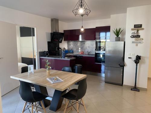 een keuken met een houten tafel en een koelkast bij Douillet BY DREAM APARTMENTS in Serris