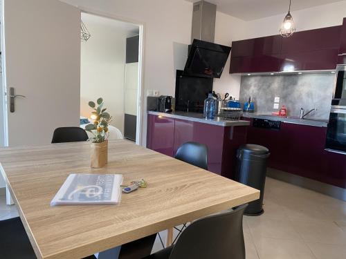 een keuken met een houten tafel met een boek erop bij Douillet BY DREAM APARTMENTS in Serris