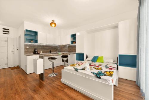 a white bedroom with a bed and a kitchen at Didi`s Stylish Studio - Seaview & Pool Backyard in Varna City