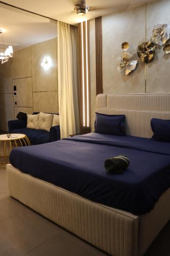 een slaapkamer met een groot bed met een kussen erop bij High Sky inn in Noida