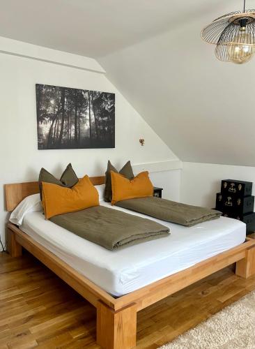 a bedroom with a large bed with orange pillows at l'Alchimiste - Appartement moderne avec jacuzzi in Bitche