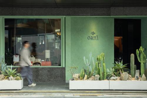 a man walking in front of a store with cactus at Oani in Taipei