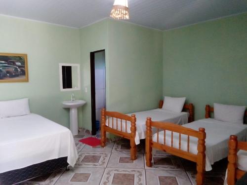 una camera con due letti e un lavandino in esso di Pousada Da Mata a Pirenópolis