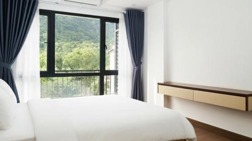 Un dormitorio con una cama y una ventana grande. en Trang an Apartment, en Kon Rung (1)