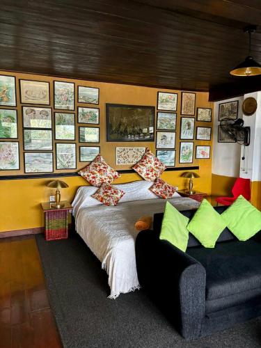 a bedroom with a large bed and a couch at Rugby House Kandy in Kandy
