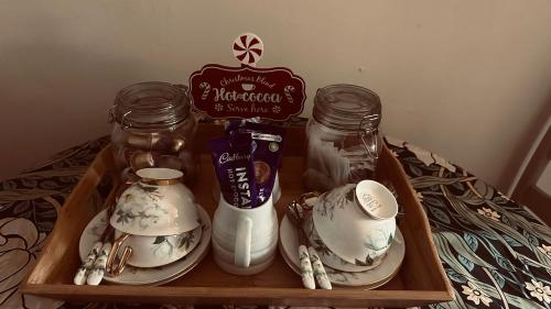 a tray with two glass jars and plates on a table at 18th Century Thatched Cottage Parking & Garden in Beaminster