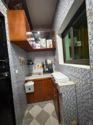 una piccola cucina con un lavandino e una finestra di Bmb house a Abidjan