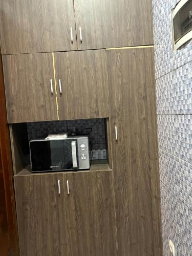 un forno a microonde posizionato all'interno di alcuni mobili di legno di Bmb house a Abidjan
