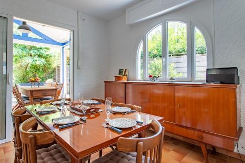 ein Esszimmer mit einem Holztisch und Stühlen in der Unterkunft Villa 3 chambres dans le centre du Cap Ferret in Lège-Cap-Ferret