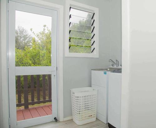 una cucina con porta che conduce a un balcone di 2 Bedroom House - Villa Teremoana a Ngatangiia