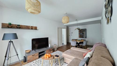 a living room with a couch and a flat screen tv at Downtown Funchal Bohemian Charm in Funchal
