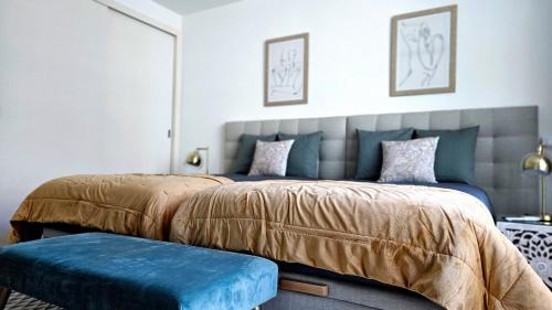 a bedroom with two beds and a blue bench at Downtown Funchal Bohemian Charm in Funchal