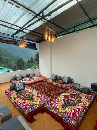 two large beds in a room with a large window at Trippy Homestay in Kasol