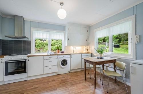 eine Küche mit weißen Geräten sowie einem Tisch und Stühlen in der Unterkunft A Cozy Nordic Home in Ålset