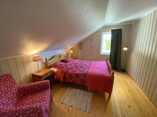 ein Schlafzimmer mit einem Bett, einem Stuhl und einem Fenster in der Unterkunft A Cozy Nordic Home in Ålset