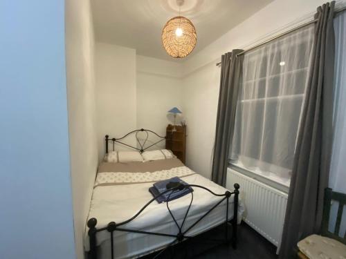 a small bedroom with a bed and a window at EGHAM LOVELY STUDIO SELF CONTAINED 2 mins station in Egham