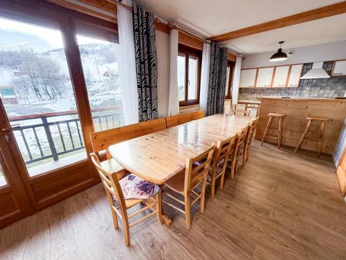 ein Esszimmer mit einem Holztisch und Stühlen in der Unterkunft Appartement spacieux à Saint-Sorlin-d'Arves 87 m² vue montagne in Saint-Sorlin-dʼArves