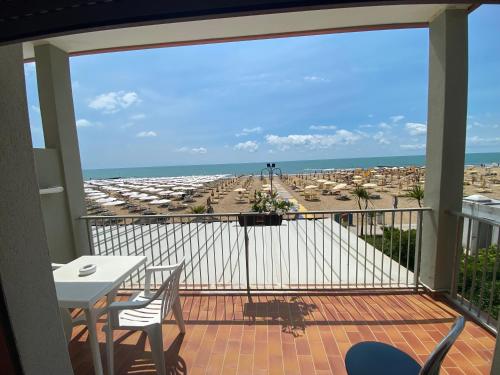 リド・ディ・イエゾロにあるVilla Gardaのビーチの景色を望むバルコニー(テーブル、椅子付)
