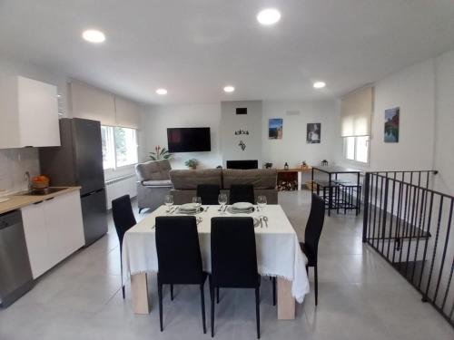 una cucina e una sala da pranzo con tavolo e sedie di Alojamiento Rural El Lentisco 