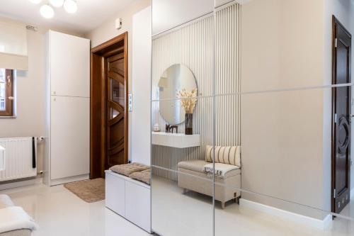 a bathroom with a mirror and a vanity with a chair at TatryTop Dom Tatra Home Residence Jacuzzi in Biały Dunajec