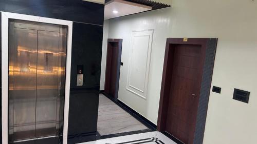 a hallway with two elevators and a door in a room at Hotel Rashmi Grand in Khagaria