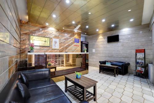 een woonkamer met een bank en een open haard bij Hotel Nancy Dx Near New Delhi Railway Station in New Delhi