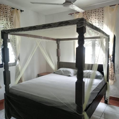 een slaapkamer met een hemelbed in een kamer bij 1Bedroom Villas- Serena, Mombasa in Mombasa
