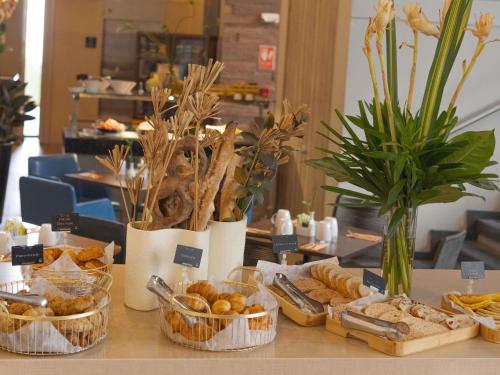 a table topped with baskets of bread and pastries at Novotel Medellin El Tesoro in Medellín