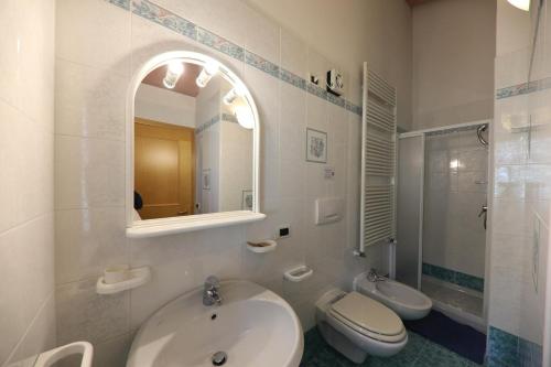 a bathroom with a sink and a toilet and a mirror at Villa Marta in Mazzin