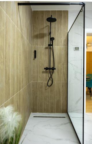 a shower with a glass door in a bathroom at Grand Chalet Ramina in Poiana Brasov