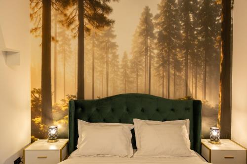 a bedroom with a green bed with a painting of trees at Grand Chalet Ramina in Poiana Brasov
