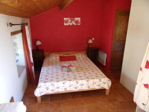 ein Schlafzimmer mit einem Bett mit zwei Stofftieren darauf in der Unterkunft Gîte de charme la Fenière in Joyeuse