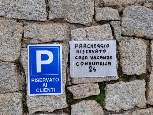 a parking sign on the side of a brick wall at Consumella24 in Portoferraio