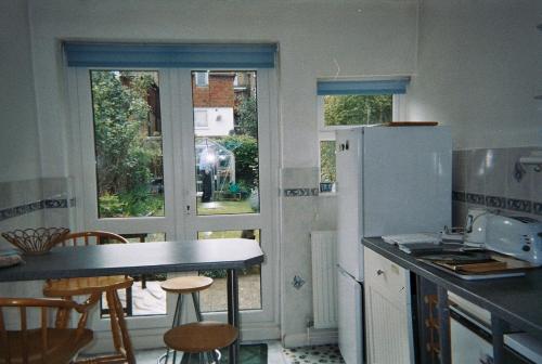 リトルハンプトンにあるStafford Houseのキッチン(冷蔵庫、テーブル、椅子付)