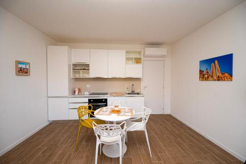 een keuken en eetkamer met een tafel en stoelen bij San Pier Tommaso Living in Bologna