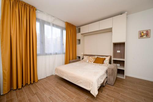 een slaapkamer met een bed met een oranje gordijn bij San Pier Tommaso Living in Bologna