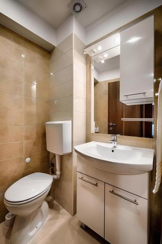 a bathroom with a white toilet and a sink at Riva Suite 1 in Komiža