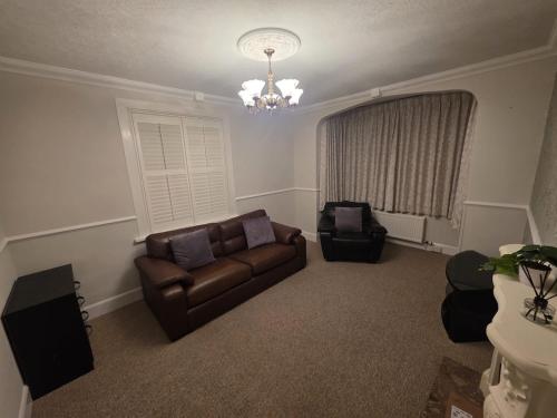 a living room with a couch and a chandelier at The Nook in Taunton