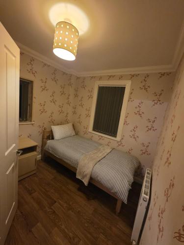a small bedroom with a bed and a lamp at The Nook in Taunton