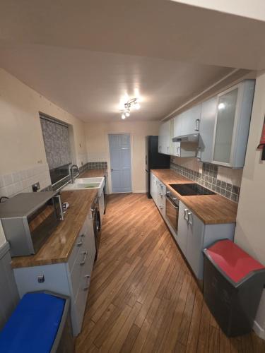a large kitchen with wooden floors and white cabinets at The Nook in Taunton