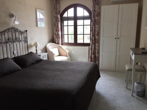 a bedroom with a bed and a desk and a window at Logis Hôtel Le Manoir & Lounge in Apt