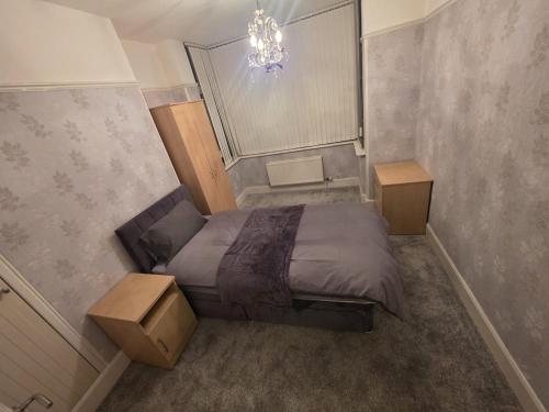 a small bedroom with a bed and a chandelier at The Nook in Taunton