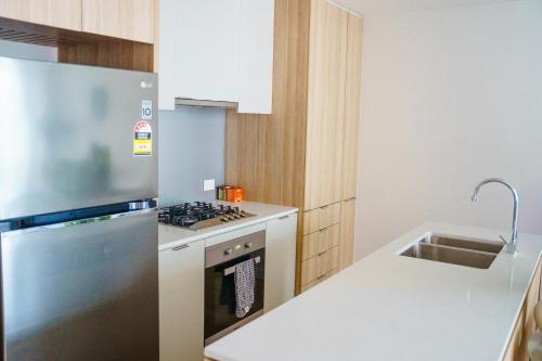 a kitchen with a stainless steel refrigerator and a sink at Sydney CBD luxury high level 2 bedroom2 bathroom condo with City view- Pool Gym 4 in Sydney
