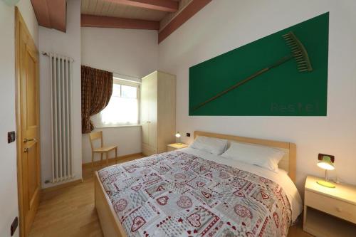 a bedroom with a bed with a green clock on the wall at Villa Marta in Mazzin