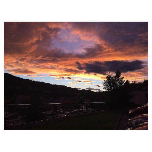a sunset in the sky over a city at Hotel La Torre in Castiglione dʼIntelvi
