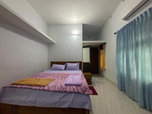 a bedroom with a large bed with purple sheets at Dream House Near IIM Kozhikode & NIT Calicut in Kozhikode