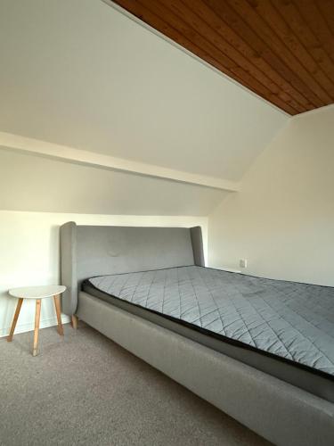 een slaapkamer met een bed en een kleine tafel bij Hobro Living House in Hobro