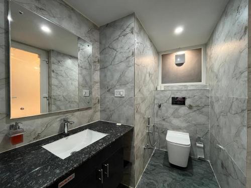 a bathroom with a sink and a toilet and a mirror at Muchaan Resort in Gochar