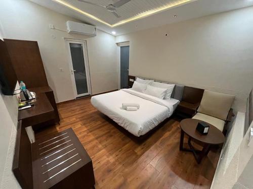 a bedroom with a white bed and a table at Muchaan Resort in Gochar