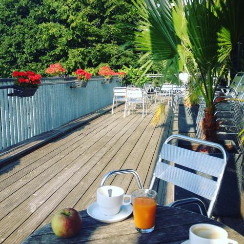a table with an apple and orange juice on a deck at Hostel De Veurs in Sint-Martens-Voeren